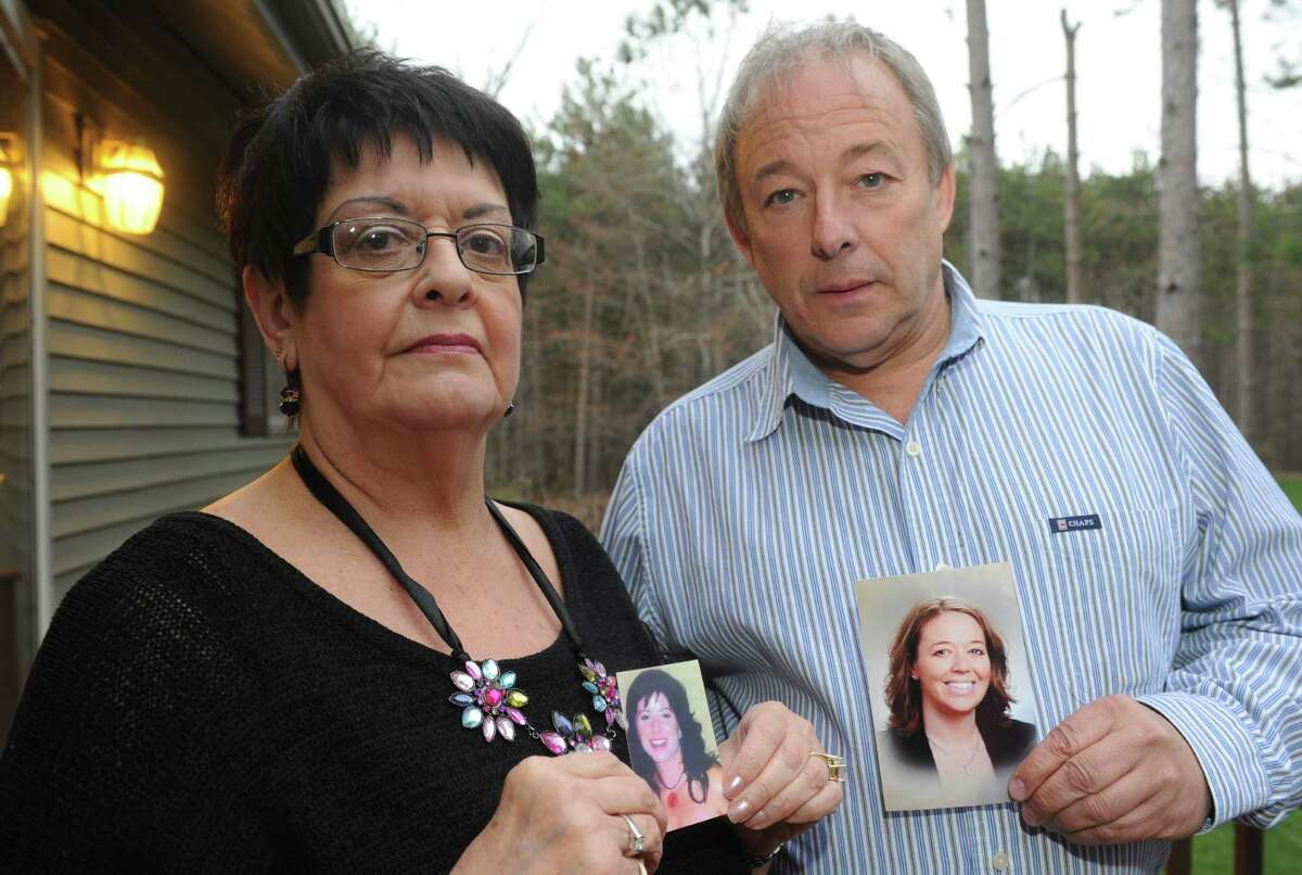 Martha Lasher-Warner and Bill Hart hold photographs of their daughters,who where both killed in domestic violence attacks, on Thursday April 18, 2013 in East Greenbush, N.Y. (Michael P. Farrell/Times Union)