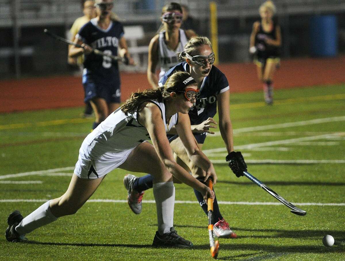 Trumbull's Maddie Buzzeo, left, and Wilton's Gwen Hall converge on the ball during their FCIAC field hockey game at Trumbull High School in Trumbull, Conn. on Monday, October 17, 2016.