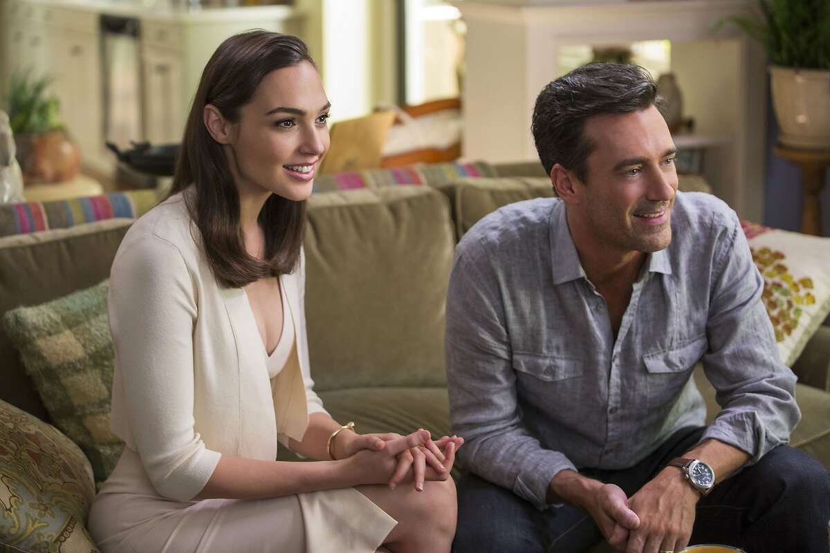 This image released by Twentieth Century Fox shows, Gal Gadot, left, and Jon Hamm in "Keeping Up With The Joneses." (Frank Masi/Twentieth Century Fox via AP)