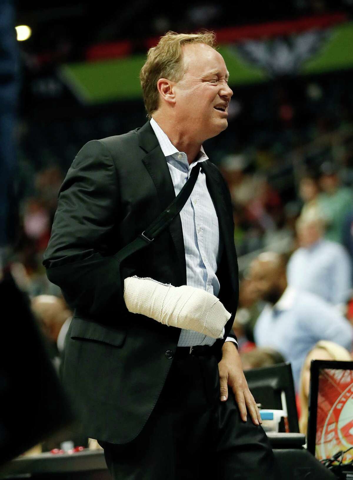 Atlanta Hawks coach Mike Budenholzer holds his leg and grimaces after he was run over on the sideline during the first half of the team's preseason NBA basketball game against the New Orleans Pelicans on Tuesday, Oct. 18, 2016, in Atlanta. Budenholzer, who was already nursing an injured hand, left the game. (AP Photo/John Bazemore)