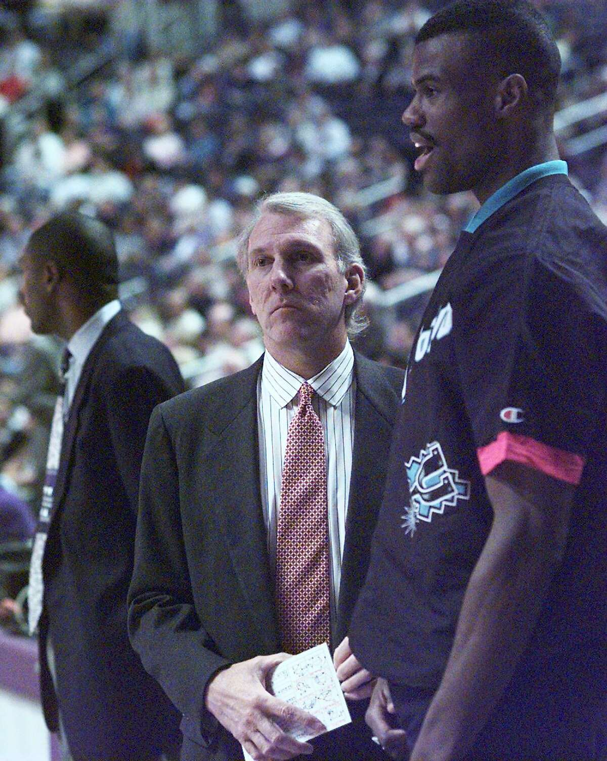 New Coach Gregg Popovich and David Robinson confer just before the start of the game in Phoenix against the Suns on Dec. 10, 1996, which the Spurs lost.