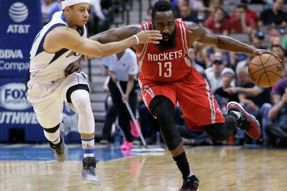 The Rockets' James Harden fends off the Mavericks' Seth Curry during the first half Wednesday night.