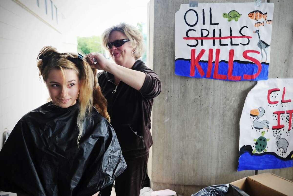 Jan White cuts Avery Welch's hair, 14, as students, friends and family at AITE get their hair cut in Stamford, Conn. on Thursday May 13, 2010 to send to an organization that is using human hair to absorb the oil spilled into the Gulf of Mexico when the BP oil rig exploded.