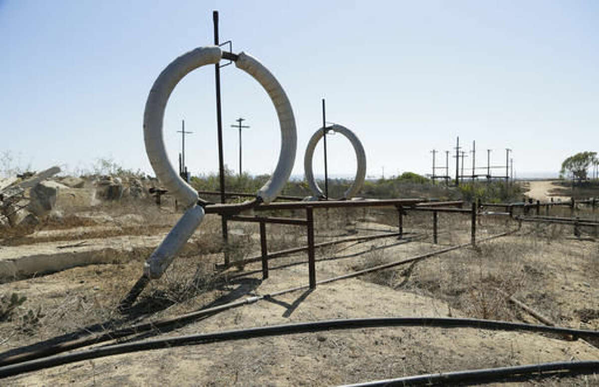 FILE - This Aug. 18, 2016 file photo shows what remains of an oil-extraction operation in Banning Ranch, on what is believed to be the biggest piece of privately-owned vacant land on Southern California's coast in Newport Beach. The California Coastal Commission will hold a hearing in Newport Beach on Wednesday, Sept. 7, 2016, on the plan to build 895 homes, a 75-room hotel and retail complex on the 401-acre site long used for oil drilling. (AP Photo/Nick Ut, File)