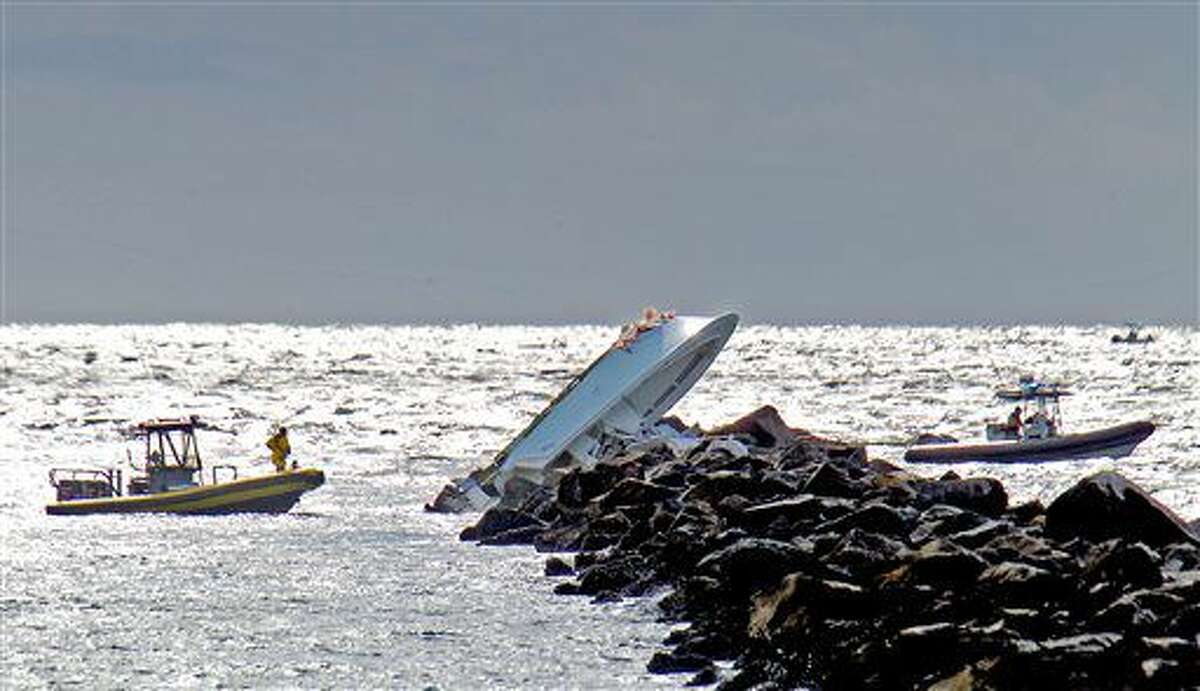 A boat lies overturned on a jetty, Sunday, Sept. 25, 2016, off Miami Beach, Fla. Authorities said that Miami Marlins starting pitcher Jose Fernandez was one of three people killed in the boat crash early Sunday morning. Fernandez was 24. (Patrick Farrell/Miami Herald via AP)
