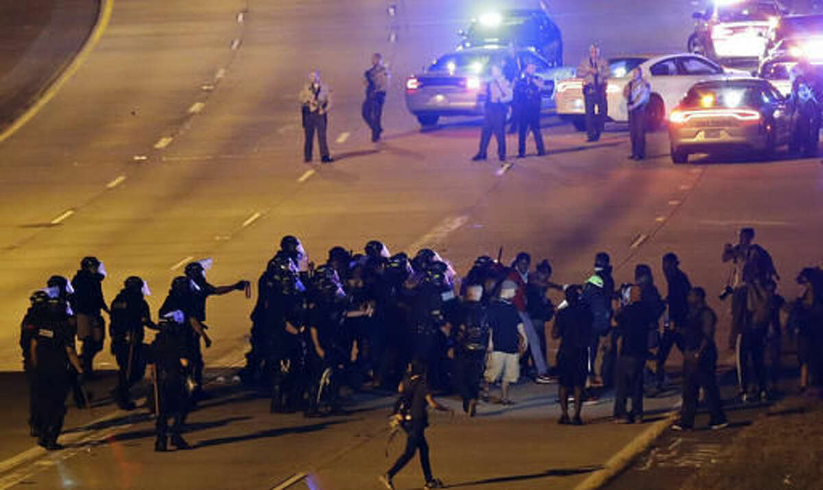 Police confront protesters blocking I-277 during a third night of unrest following Tuesday's police shooting of Keith Lamont Scott in Charlotte, N.C., Thursday, Sept. 22, 2016. (AP Photo/Gerry Broome)