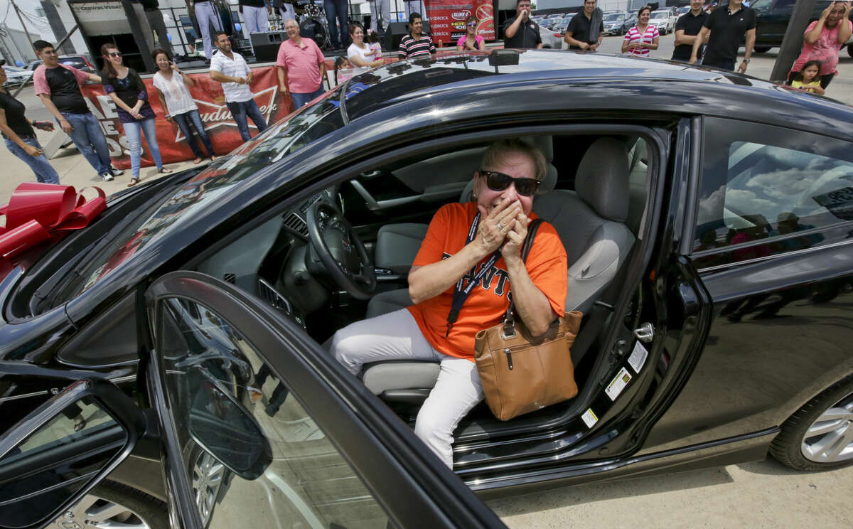 Rosa Astudillo reacts after her key started the engine of a 2015 Honda Civic on Saturday afternoon during the Sames Honda Ultimate Car Giveaway. Astudillo's key, the fifth of 30 keys drawn by contestants, started the car, making her the proud owner of the 2015 Honda Civic.