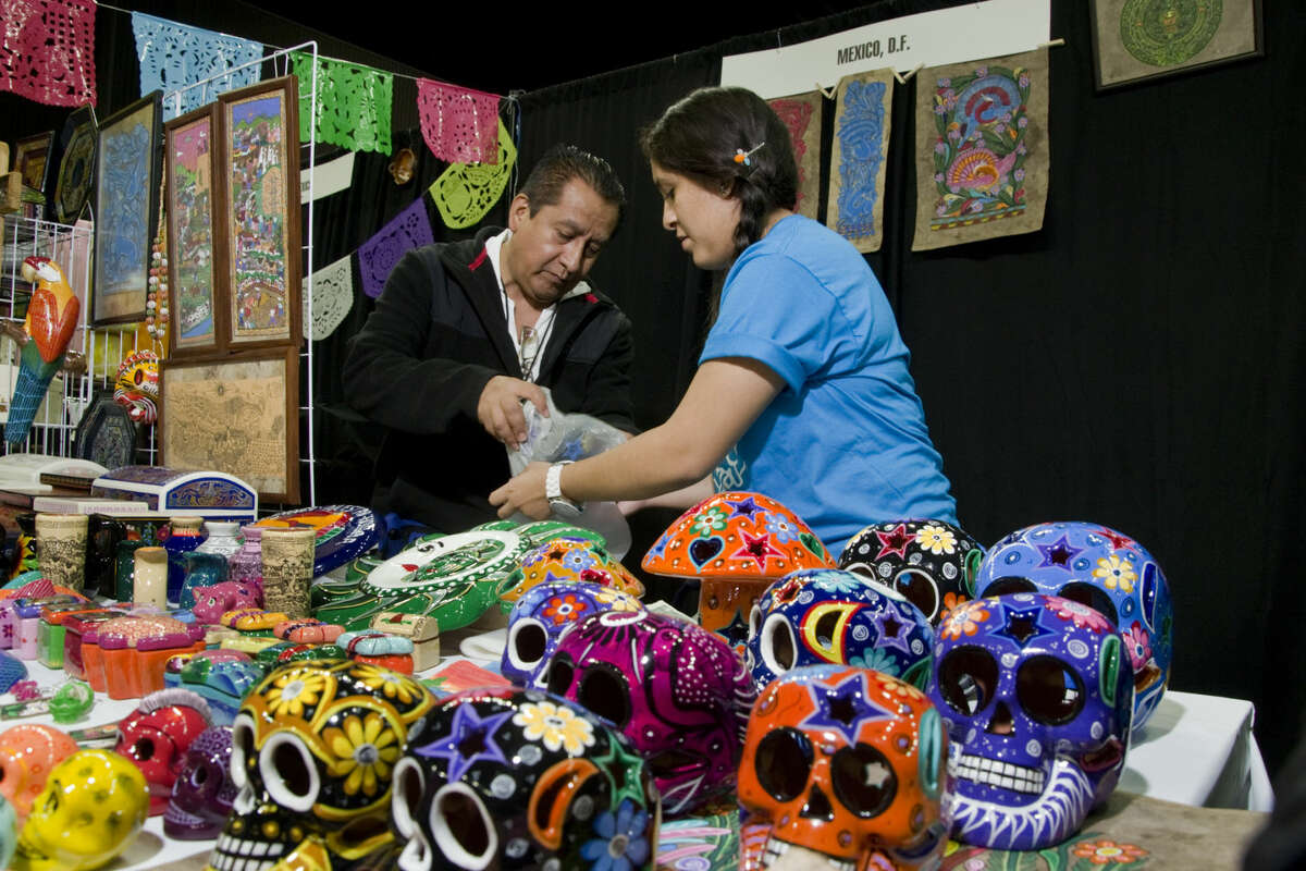 In this file photo, Alberto Martinez and Alejandra Eligido wrap up one of the curios purchased by a customer at the Laredo Energy Arena during the Sister Cities Festival.