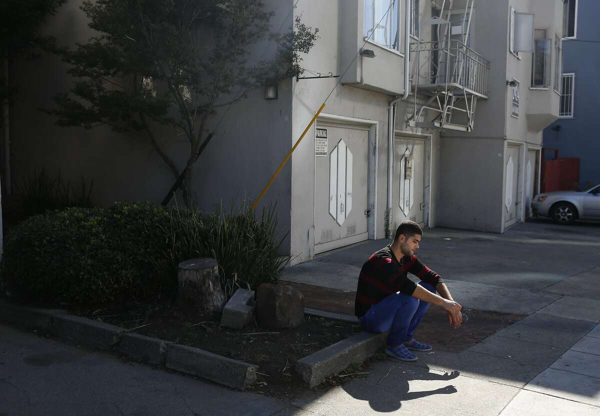 Mohanad Hussien, 23, takes a smoke break outside of his apartment Oct. 20, 2016 in Oakland, Calif. The Syrian family has recently been resettled in Oakland after spending a few years in Jordan after fleeing the Syrian civil war.