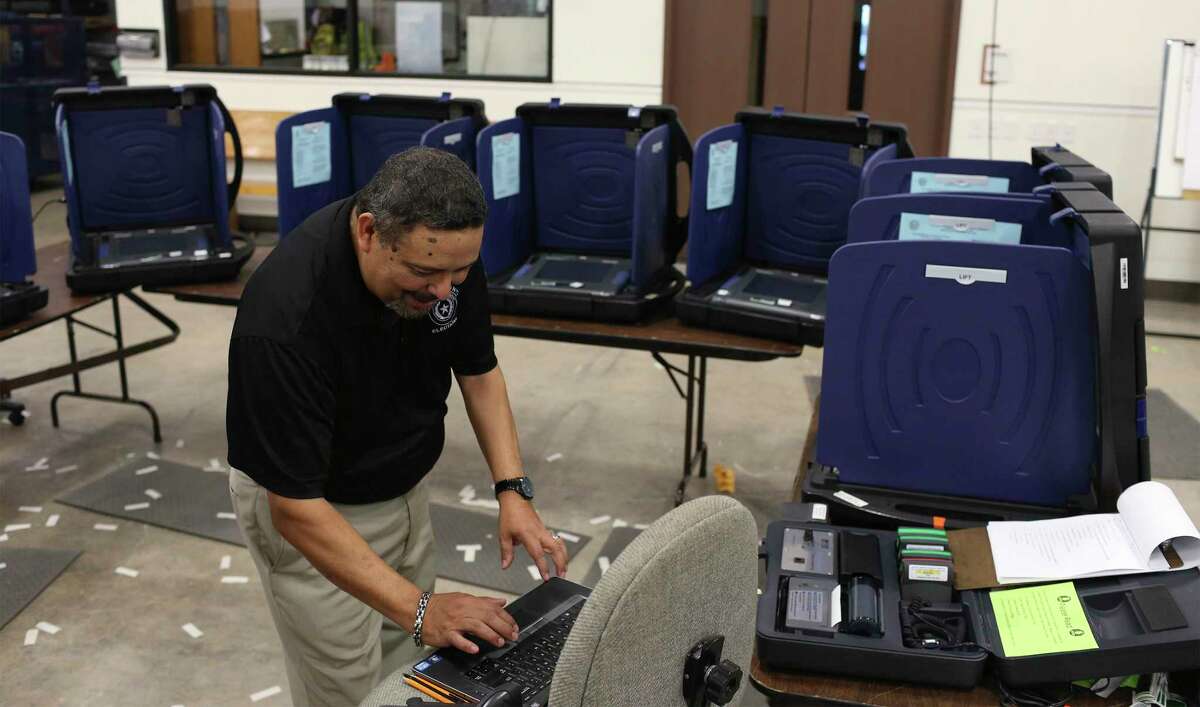 Bexar County Elections Department operations coordinator Joe Camacho loads election information into voting machines for the general election in Ocotober 2016.
