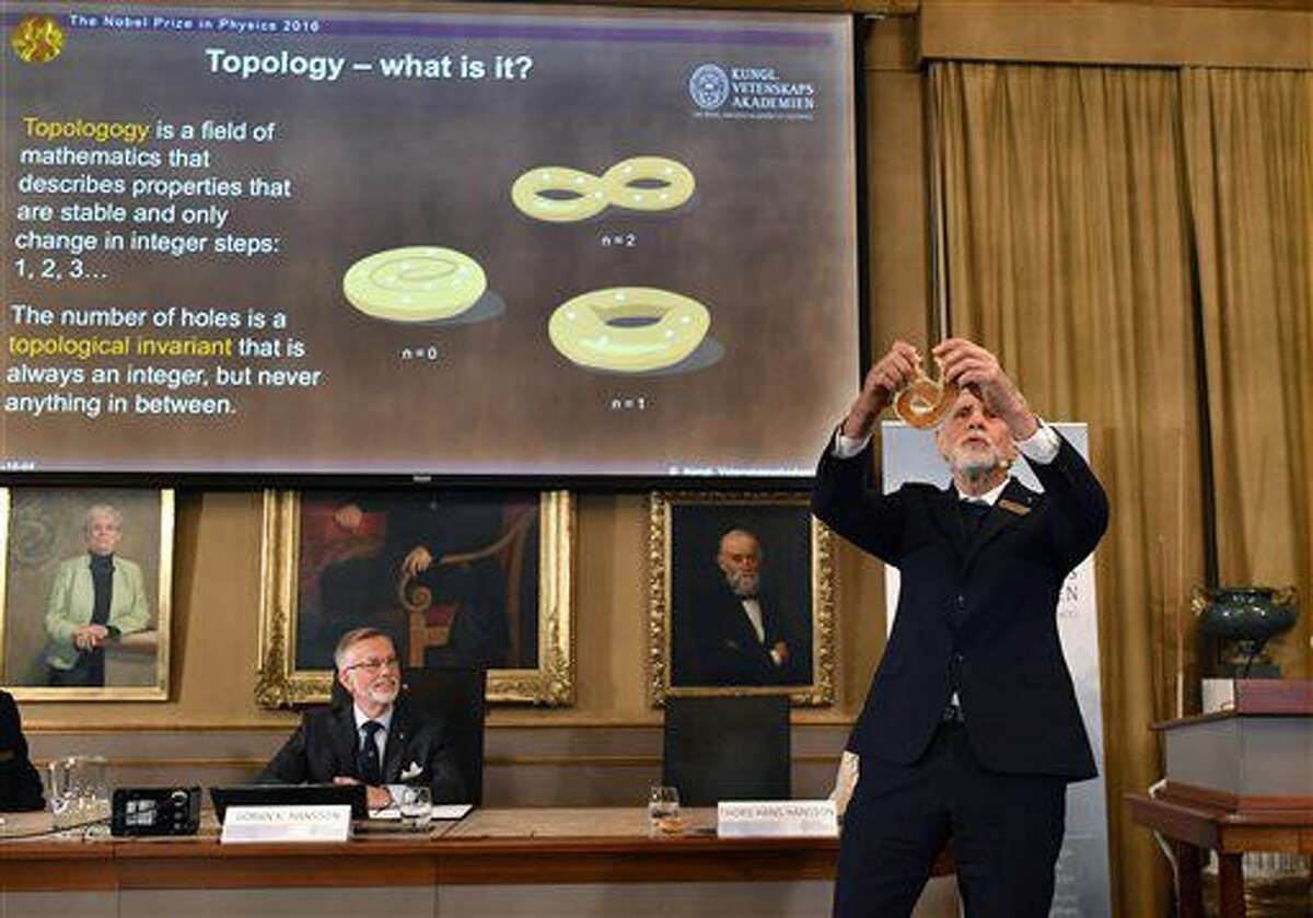 Professor Thors Hans Hansson gives a demonstration, after revealing the winners of the Nobel Prize in physics, at the Royal Swedish Academy of Sciences, in Stockholm, Sweden, Tuesday, Oct. 4, 2016. David Thouless, Duncan Haldane and Michael Kosterlitz have won the Nobel physics prize. Nobel jury praises physics winners for 'discoveries of topological phase transitions and topological phases of matter'. (Anders Wiklund /TT via AP)