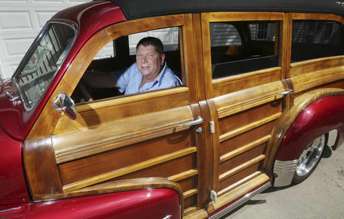 In this Sept. 14, 2016 photo, Randy Goodrich sits in his 1948 Pontiac Woody Wagon that is made of approximately 50% wood at his home in Decatur, Ill. Goodrich said that 68 years ago, Pontiac didn't actually make a station wagon. They built an already magnificent Silver Streak sedan and then shipped very few of them off to the Ionia Mfg. Co. in Michigan, which did the station wagon bodywork in wood. (Jim Bowling/Herald & Review via AP) /Herald & Review via AP)
