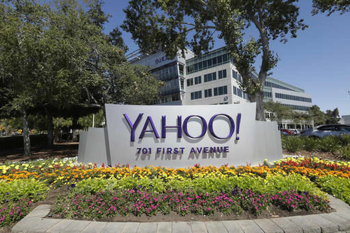 In this Tuesday, July 19, 2016, photo, flowers bloom in front of a Yahoo sign at the company's headquarters in Sunnyvale, Calif. Yahoo responded again on Wednesday, Oct. 5, 2016, to a report that it scanned incoming email to hundreds of millions of accounts for the U.S government. In a carefully worded statement that stops short of a denial, the company said a Tuesday Reuters report is “misleading,” saying that “the mail scanning described in the article does not exist on our systems.” (AP Photo/Marcio Jose Sanchez)