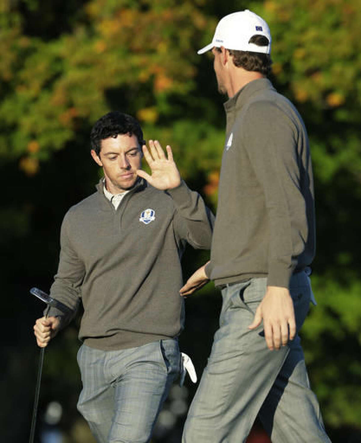 Europe’s Rory McIlroy high fives Europe’s Thomas Pieters on the second hole during a foresomes match at the Ryder Cup golf tournament Saturday, Oct. 1, 2016, at Hazeltine National Golf Club in Chaska, Minn. (AP Photo/Charlie Riedel)