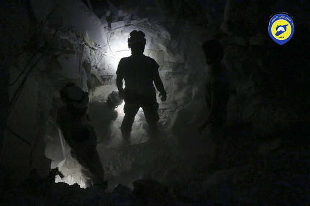 This Tuesday, Oct. 4, 2016 photo, provided by the Syrian Civil Defense group known as the White Helmets, shows Civil Defense workers from the White Helmets digging in the rubles to remove bodies and look for survivors, after airstrikes hit Bustan al-Basha neighborhood in Aleppo, Syria. The U.N. on Wednesday released stark satellite images showing the most recent destruction of Syria's embattled northern city of Aleppo, pounded by Syrian and Russian airstrikes since the collapse of a U.S.-Russia brokered cease-fire two weeks ago. (Syrian Civil Defense White Helmets via AP)