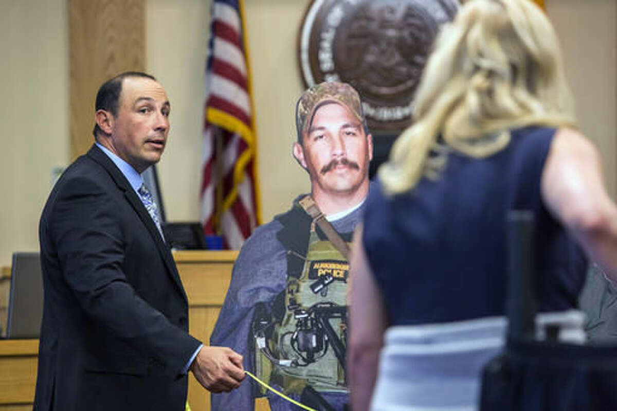 Former Albuquerque police Detective Keith Sandy, stands next to a life-size cut out of himself while assisting the prosecution in demonstrating the distance he maintained during the time of the shooting, Wednesday, Oct. 5, 2016 in Albuquerque, N.M.. Attorneys in the jury trial of two former police officers charged in the killing of a homeless camper have attempted to reconstruct the scene of the standoff that ended with the officers fatally shooting the man in the arms and back. (AP Photo/Juan Labreche)
