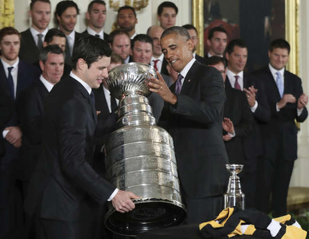 President Barack Obama helps Pittsburgh Penguins team captain Sidney Crosby carry the Stanley Cup during a ceremony honoring the Stanley Cup champion Pittsburgh Penguins, Thursday, Oct. 6, 2016, during a ceremony in the East Room of the White House in Washington. (AP Photo/Manuel Balce Ceneta)