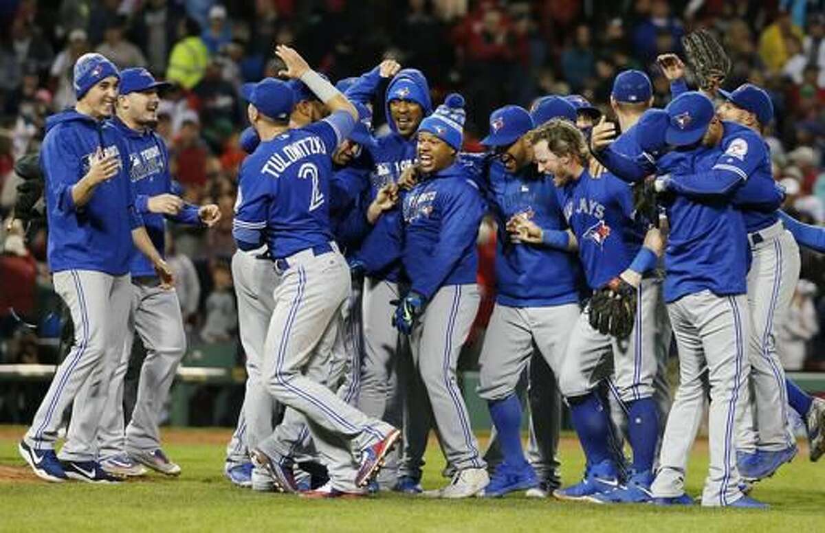 The Toronto Blue Jays celebrate after defeating the Boston Red Sox 2-1 during a baseball game in Boston, Sunday, Oct. 2, 2016. (AP Photo/Michael Dwyer)