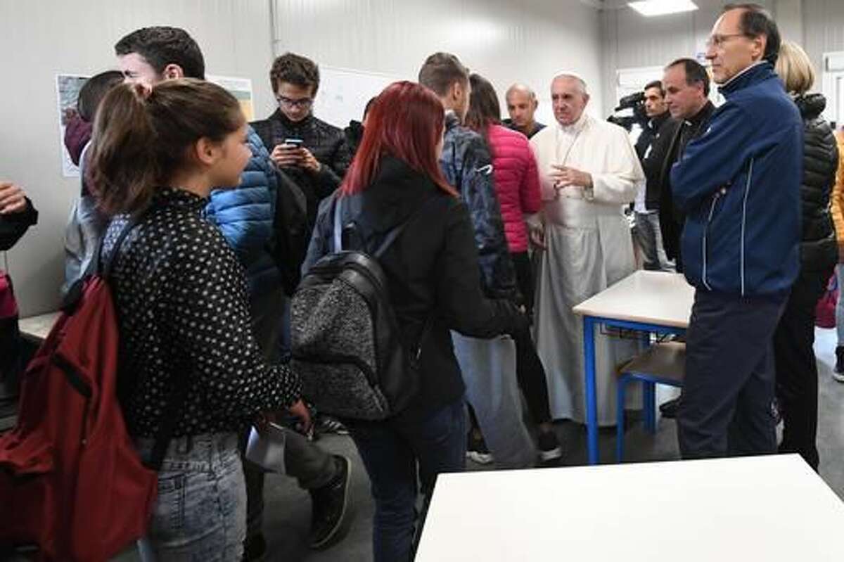 Pope Francis meets students and teachers in the temporary school which was set up in Amatrice, Italy, Tuesday, Oct. 4, 2016. Pope Francis traveled to the earthquake-hit area Tuesday to meet with the victims of the Aug. 24 quake that rattled central Italy. (Alessandro Di Meo/ANSA via AP)