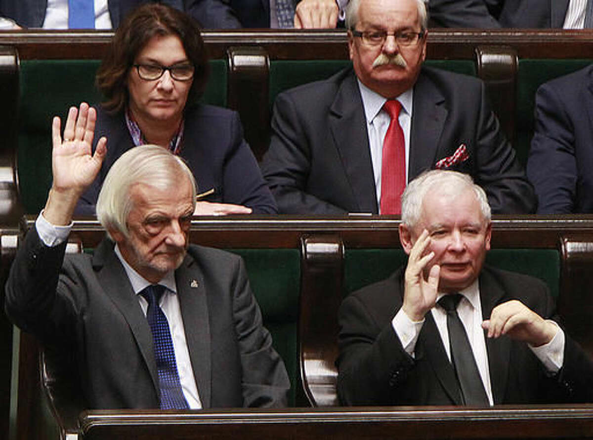 Jaroslaw Kaczynski, right, head of the ruling Law and Justice party, votes in a parliament to reject a proposal to restrict the abortion law in Warsaw, Poland, Thursday, Oct. 6, 2016. He was one of the lawmakers who objected a proposal by an anti-abortion group that would have imposed a total ban on abortion. (AP Photo/Czarek Sokolowski)