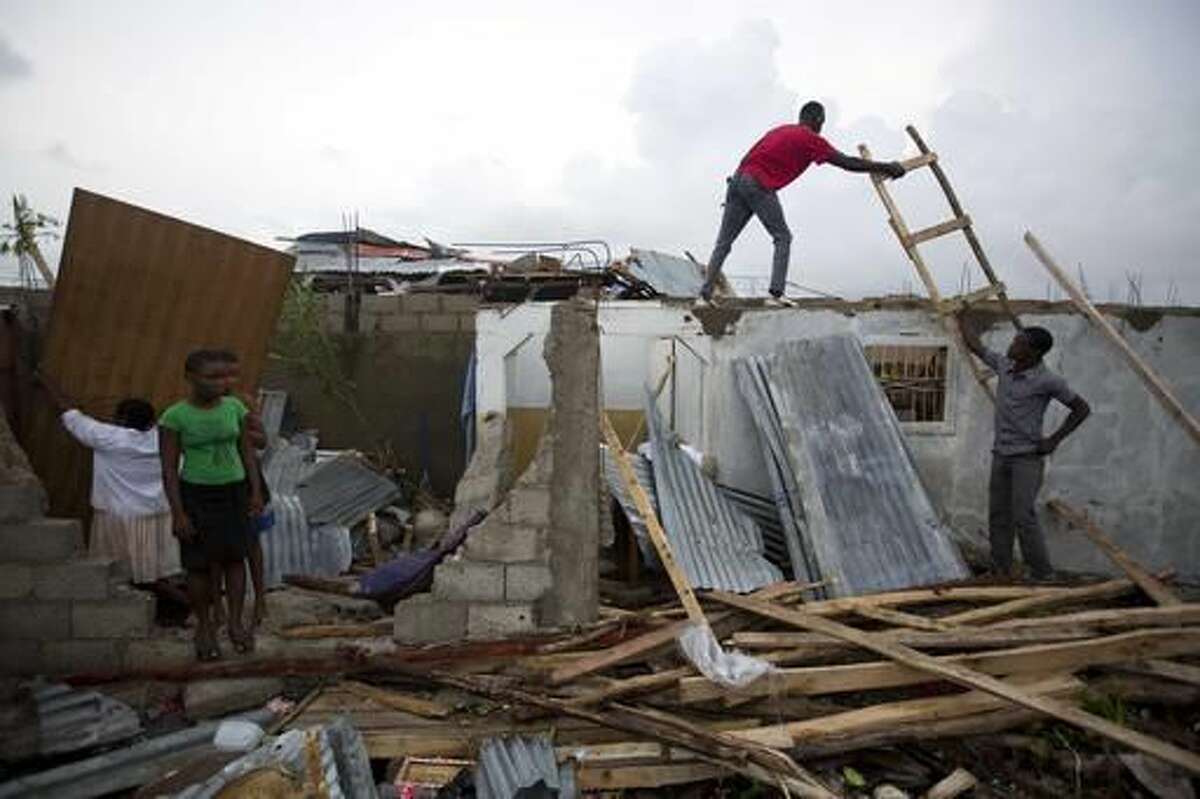 Residents repair their homes destroyed by Hurricane Matthew in Les Cayes, Haiti, Thursday, Oct. 6, 2016. Two days after the storm rampaged across the country's remote southwestern peninsula, authorities and aid workers still lack a clear picture of what they fear is the country's biggest disaster in years. (AP Photo/Dieu Nalio Chery)