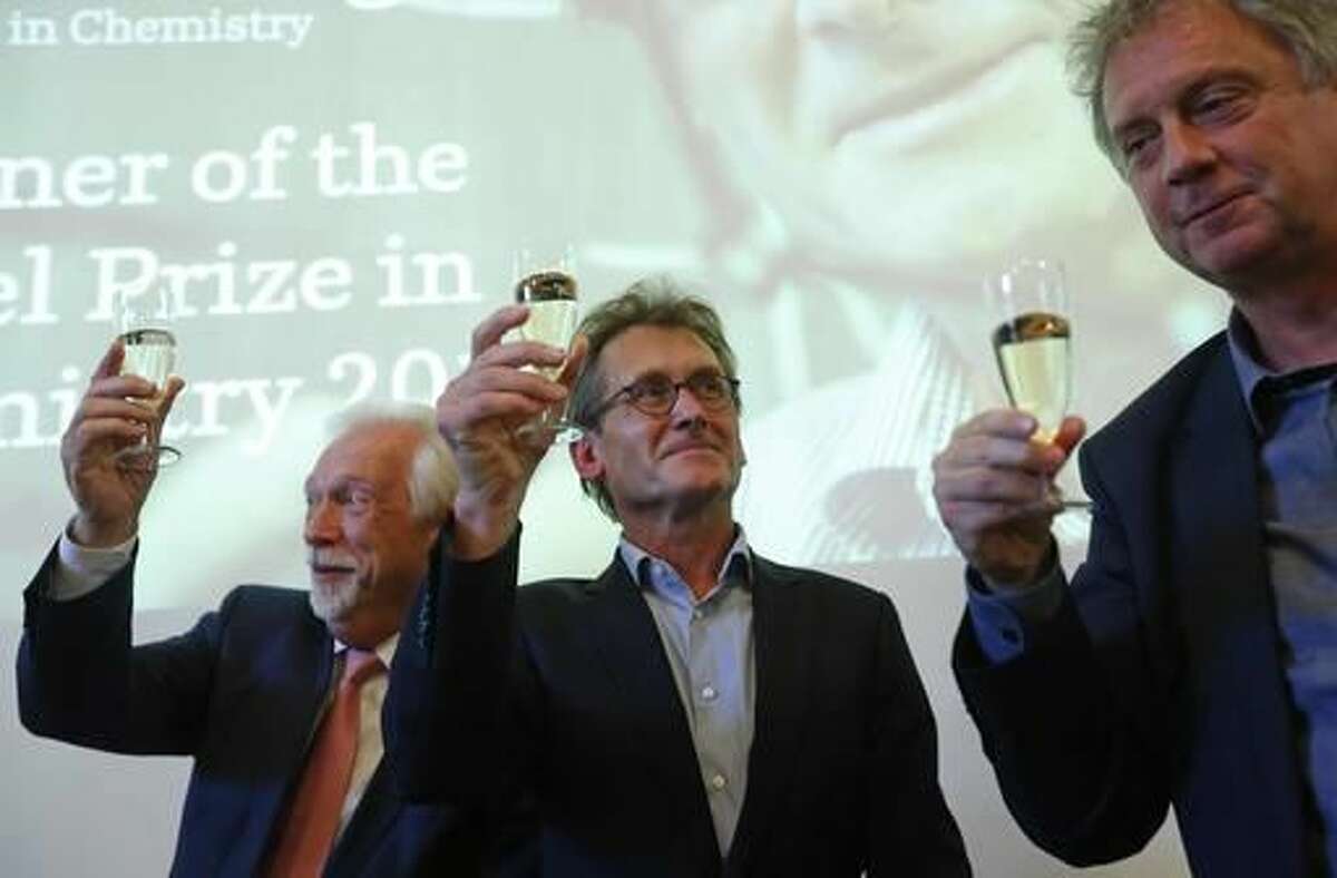 Dutch scientist Bernard "Ben" Feringa, centre, Elmer Sterken, the Rector Magnificus at the University of Groningen, right, and Sibrand Poppema, the President of the University, toast with champagne after a press conference at the University of Groningen in the Netherlands, Wednesday Oct. 5, 2016 Feringa was one of the three scientists who won the Nobel Prize in chemistry on Wednesday for developing the world's smallest machines, work that could revolutionise computer technology and lead to a new type of battery. (AP Photo/Peter Dejong)