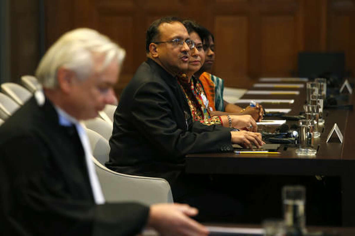Phon van den Biesen, lawyer for the Marshall Islands, left, India's Ambassador J.S. Mukul, third right, and other representatives of the Indian delegation wait for the start of the World Court session in The Hague, Netherlands, Wednesday, Oct. 5, 2016, where the Marshall Island are taking India, Pakistan and the U.K. to court to urge those powers to resume negotiations to eradicate the world's nuclear stockpile. (AP Photo/Peter Dejong)