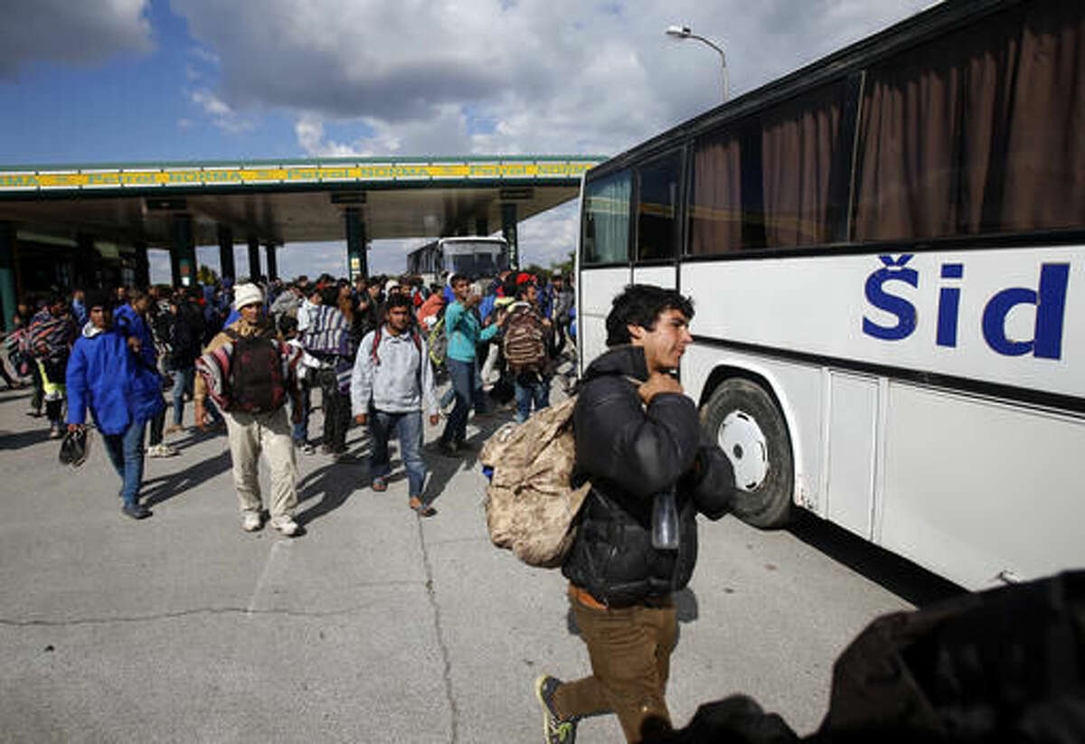 Migrants board a bus at a local gas station near the town of Indjija, about 40 kilometers (24 miles) north of the Belgrade, Serbia, Wednesday, Oct. 5, 2016. More than one hundred migrants who set off on foot toward the Hungarian border have agreed to end their protest march, demanding the border to be opened, and return to the Serbian capital of Belgrade after spending the night out in the open. (AP Photo/Darko Vojinovic)