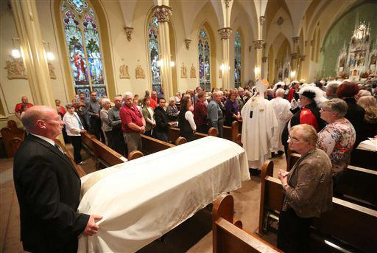 Pat Leonard, far left, escorts the casket during a Mass of remembrance for Chaplain Aloysius Schmitt on Wednesday, Oct. 5, 2016, at St. Luke's Church in St. Lucas, Iowa. Schmitt, a St. Lucas, native, died on Dec. 7, 1941, when the Japanese attacked Pearl Harbor. After nearly 75 years, his remains have been identified. (Jessica Reilly/Telegraph Herald via AP)