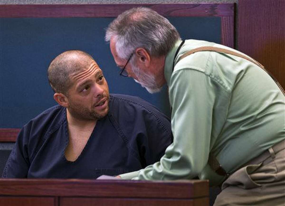 Pedro Jose Garcia, left, speaks with his deputy public defender Edward Kane as he makes his first court appearance at the Regional Justice Center in Las Vegas on Wednesday, Sept. 28, 2016. A court date was postponed until Friday for Garcia, who is accused of killing a Starbucks customer during a weekend coffee shop shooting in Las Vegas. (L.E. Baskow/Las Vegas Sun via AP)