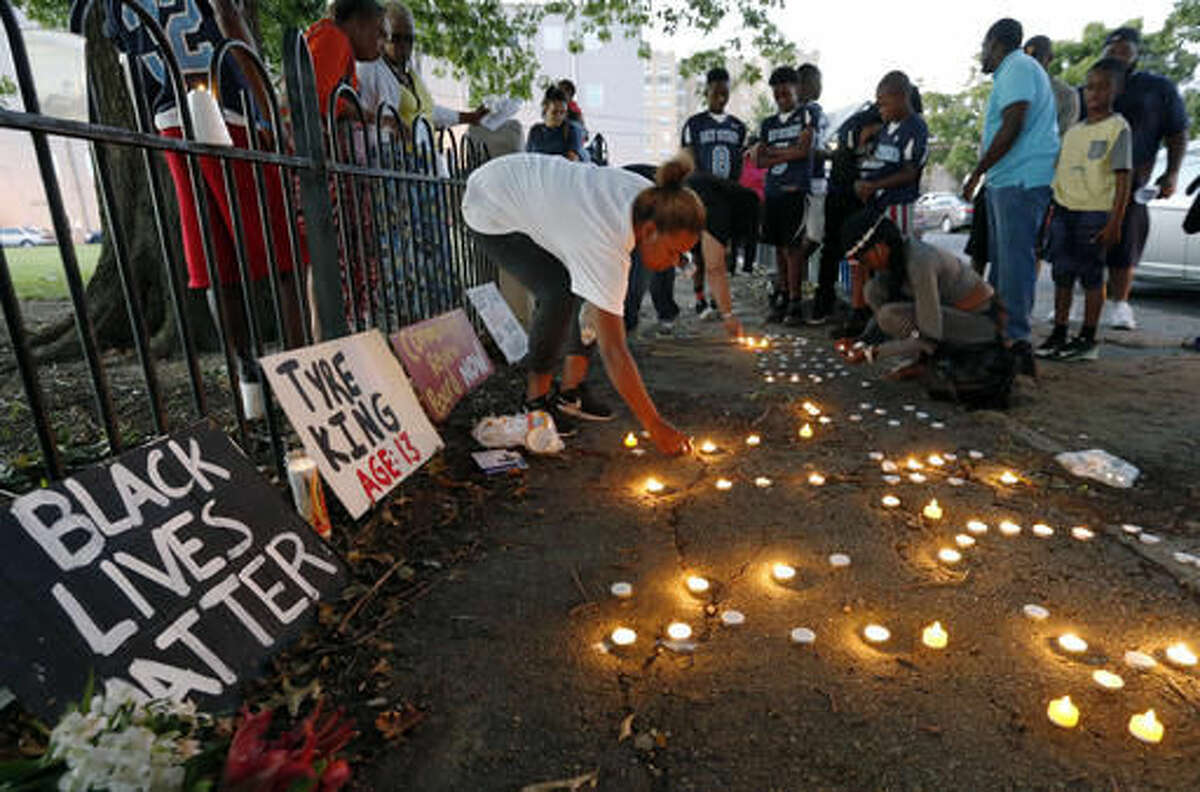 Community members light candles during a vigil for 13-year-old Tyre King Thursday, Sept. 15, 2016, in Columbus, Ohio. King was shot and killed by Columbus police Wednesday evening. (AP Photo/Jay LaPrete)