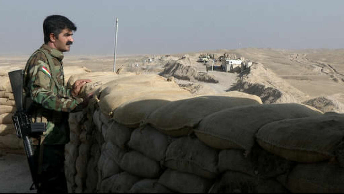 In this Monday, Sept. 5, 2016 photo made from video, a militiaman of the Kurdistan Freedom Party, an Iranian Kurdish opposition group, looks over the sandbags at a section of the frontline near the Iraqi city of Kirkuk. The leader of the armed Kurdish group in Iran says it received military weapons and explosives training from American and European advisers as part of the war against the Islamic State group. (AP Photo/Balint Szlanko)