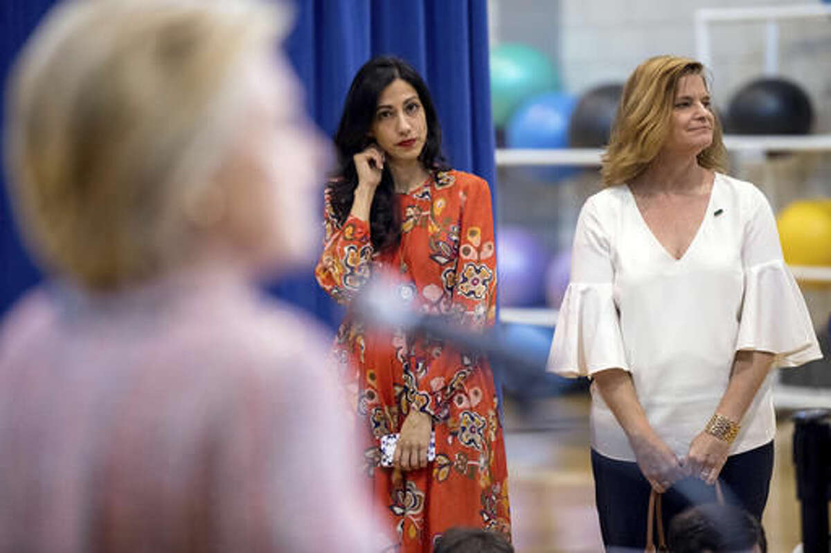 Senior aide Huma Abedin, center, and Director of Communications Jennifer Palmieri, right, stand nearby as Democratic presidential candidate Hillary Clinton answers a question from a member of the media after speaking at a rally at University of North Carolina, in Greensboro, N.C., Thursday, Sept. 15, 2016. Clinton returned to the campaign trail after a bout of pneumonia that sidelined her for three days and revived questions about both Donald Trump's and her openness regarding their health. (AP Photo/Andrew Harnik)