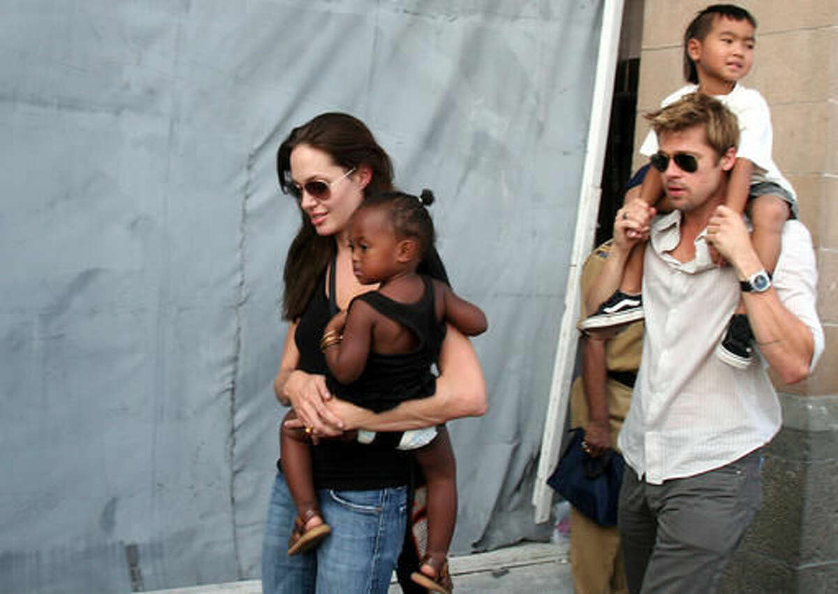 FILE - In this Nov. 12, 2006 file photo, American actress and UNHCR Ambassador Angelina Jolie, left, with her daughter Zahara, and Brad Pitt, right, with Jolie's son Maddox, walk near the Gateway of India in Mumbai, India. Angelina Jolie Pitt has filed for divorce from Brad Pitt, bringing an end to one of the world's most star-studded, tabloid-generating romances. An attorney for Jolie Pitt, Robert Offer, said Tuesday, Sept. 20, 2016, that she has filed for the dissolution of the marriage. (AP Photo, File)