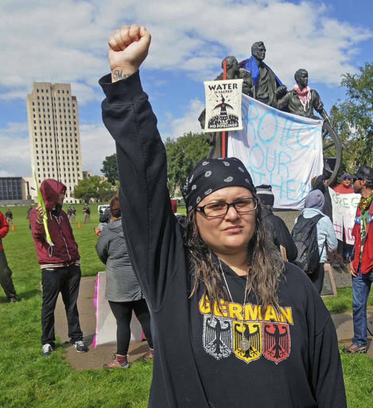 Megan Tobin, of Bellevue, Ohio protests on the grounds of the North Dakota state capitol Friday, Sept. 9, 2016 in Bismarck, N.D. The federal government stepped into the fight over the Dakota Access oil pipeline Friday, ordering work to stop on one segment of the project in North Dakota and asking the Texas-based company building it to "voluntarily pause" action on a wider span that an American Indian tribe says holds sacred artifacts. (Tom Stromme/The Bismarck Tribune via AP)