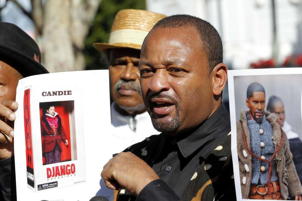 Community activist Najee Ali holds an action figure depicting Calvin Candie, Leonardo DiCaprio's character from the Quentin Tarantino film "Django Unchained", during a news conference Tuesday Jan. 8, 2013 in Los Angeles. The slavery-era figures are raising questions about whether they're appropriate. Ali, director of the advocacy group Project Islamic Hope, plans to call for the removal of the toys from the market, calling the action figures "a slap in the face of our ancestors." (AP Photo/Nick Ut)