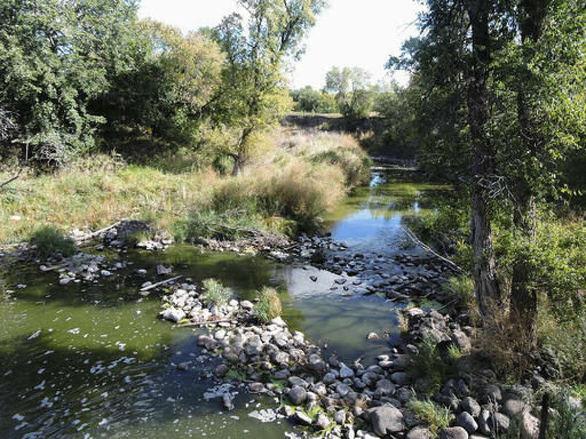 In this Sept. 16, 2016, photo, a view showing the Des Lacs River is seen at Old Settler’s Park near Burlington, N.D. State health and wildlife officials are investigating a fish kill in the river in northern North Dakota. A lack of oxygen in the water due to low river levels this summer might have caused the fish kill, according to Jason Lee, a district fisheries supervisor with the state Game and Fish Department. (Kim Fundingsland/Minot Daily News via AP)