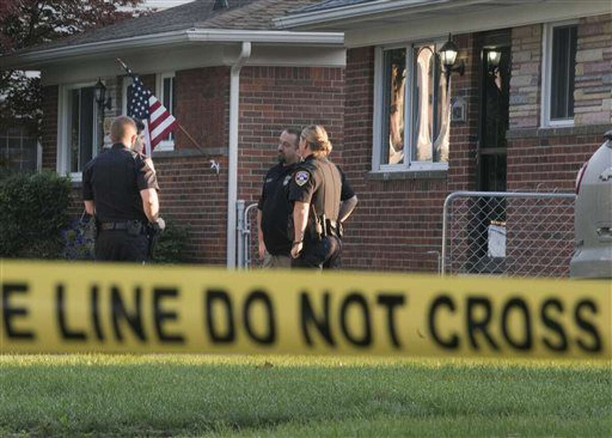 Dearborn Heights police stand outside a house at 431 Hipp street, in Dearborn Heights, Mich., on Wednesday, Sept. 21, 2016. A man is in custody after his two children were asphyxiated, his wife’s two older children were fatally shot and his wife was shot and slashed at their suburban Detroit home, police said Wednesday. (Daniel Mears/The Detroit News via AP )