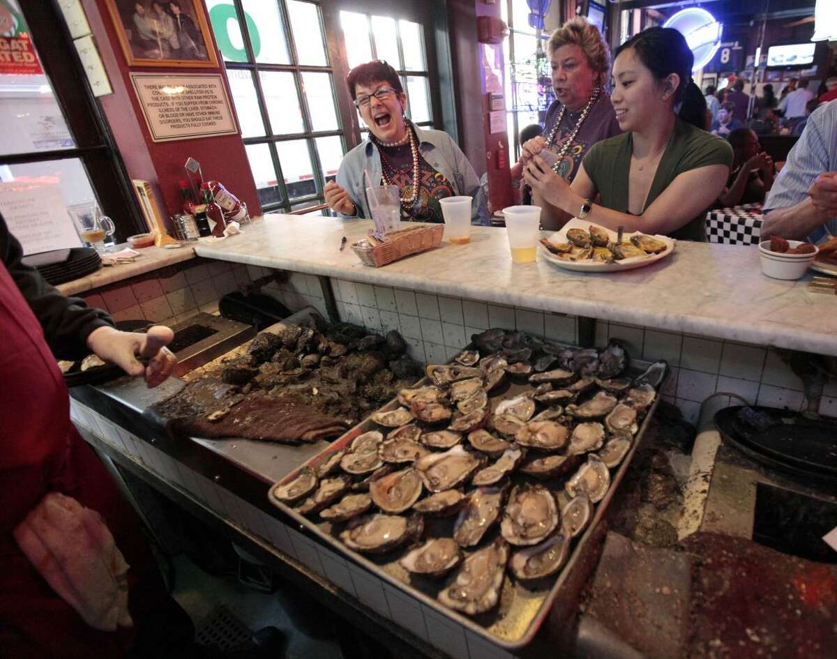 In this May 4, 2011 file photo, raw oysters are served to customers at the oyster bar inside the Acme Oyster House in New Orleans. Tradition will hold for Cajun chef John Folse this Thanksgiving. "I'm confident enough that I've got a big ol' pot of oyster dressing going right now," Folse said, when asked about the availability of Gulf of Mexico oysters more than two years after the BP oil spill, and months after Hurricane Isaac raked the Louisiana coast. (AP Photo/Gerald Herbert, File)