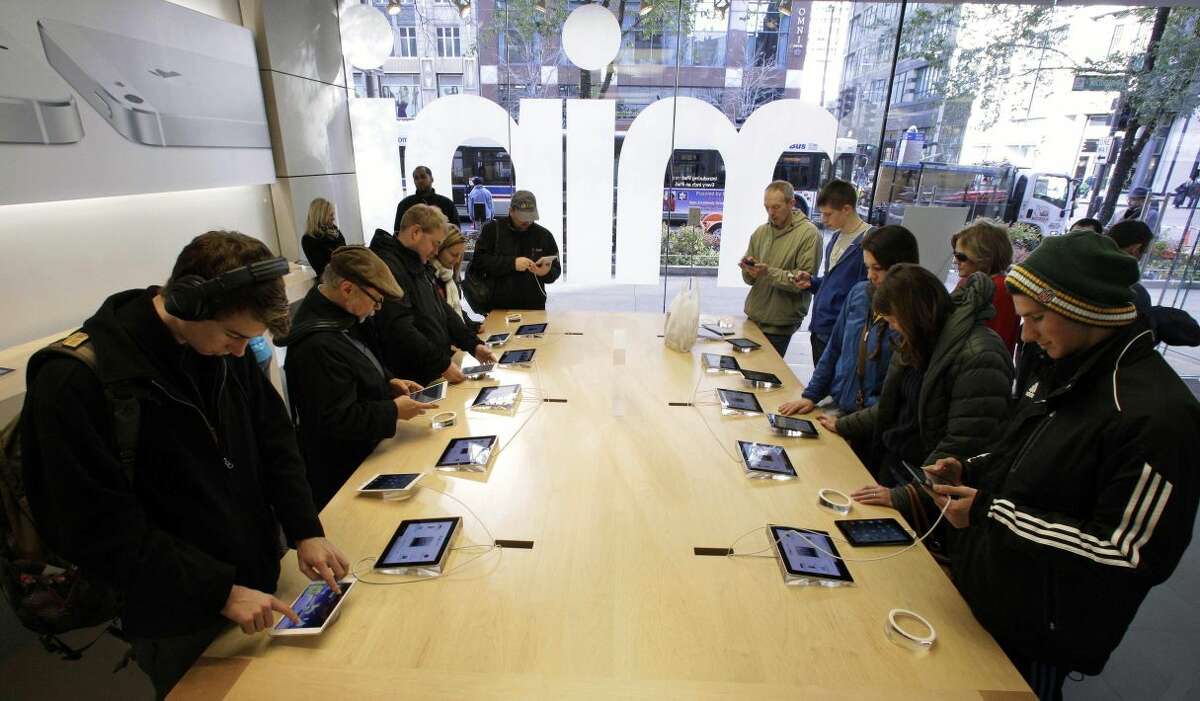 In this Friday, Nov. 2, 2012 file photo, Shoppers check out the new Apple iPad mini at the Apple store on Michigan Ave. in Chicago. Apple said Monday, Nov. 5, 2012, it sold 3 million iPads of all kinds in the first three days it sold the new Mini model. (AP Photo/M. Spencer Green, FIle)