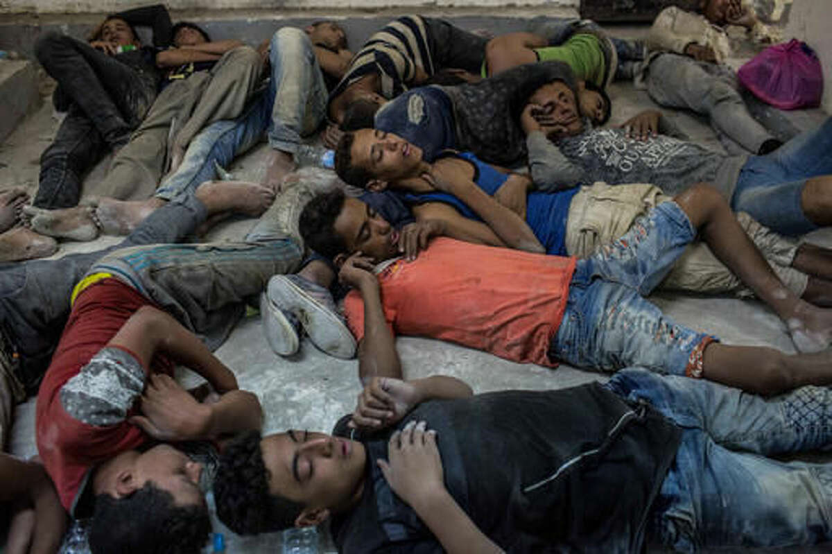 Young Egyptians detained at a police station sleep on the floor in Rosetta, Egypt, after rescued from a boat capsized off the Mediterranean coast near the Egyptian city of Alexandria, Wednesday, Sept. 21, 2016. Egypt's official news agency MENA said the boat was carrying 600 people when it sank near the coast, some 180 kilometers (112 miles) north of the capital, Cairo. (AP Photo/Eman Helal)