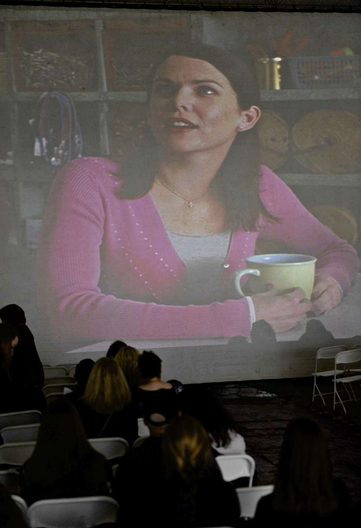 Fans watch the pilot for the "Gilmore Girls" tv show at the Gilmore Girls Fan Fest in Washington Depot, Conn, on Friday, October 21, 2016. Title character Lorelai Gilmore, played by actress Lauren Graham is on the screen.