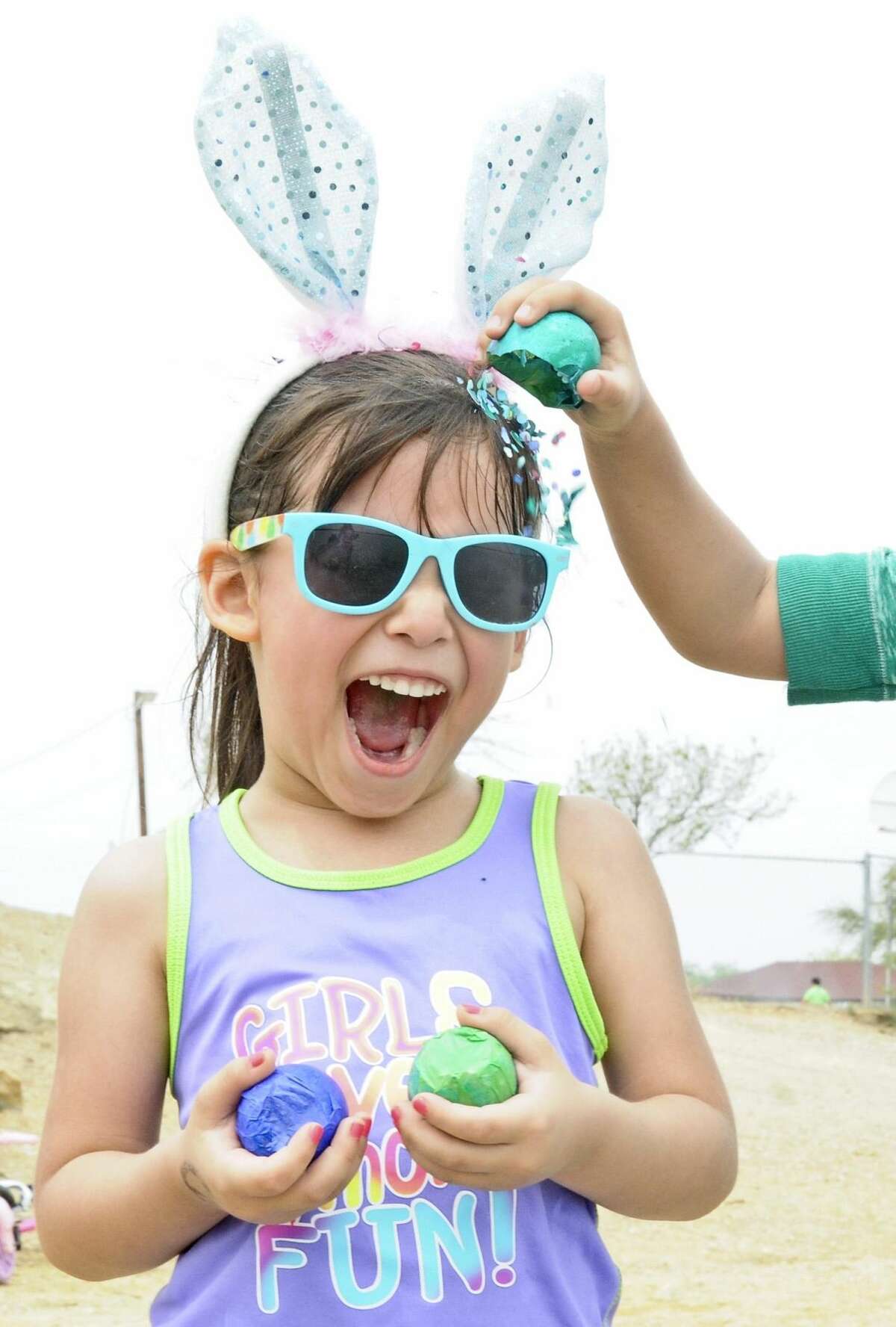 Madison Ruiz reacts as her friend cracks an Easter egg on her head at Lake Casa Blanca on Easter Sunday. Thousands of people flock to the lake every year to enjoy the day. (Photo by Ulysses S. Romero/Laredo Morning Times)