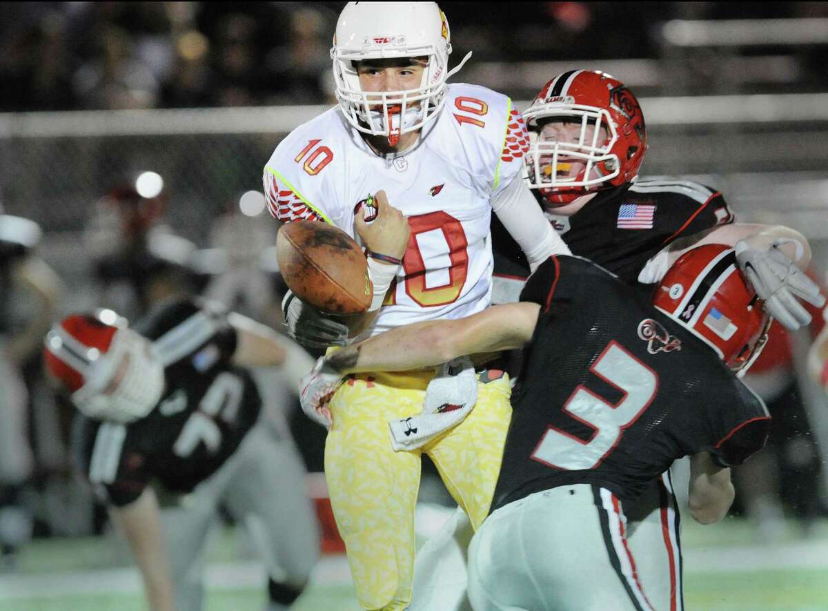 A hit by New Canaan's Grant Morse (#3), right, and teammate, Seamus O'Hora, background, causes Greenwich quarterback Connor Langan (#10) to fumble during second quarter action of the high school football game between Greenwich High School and New Canaan High School at New Canaan, Conn., Friday night, Oct. 21, 2016.