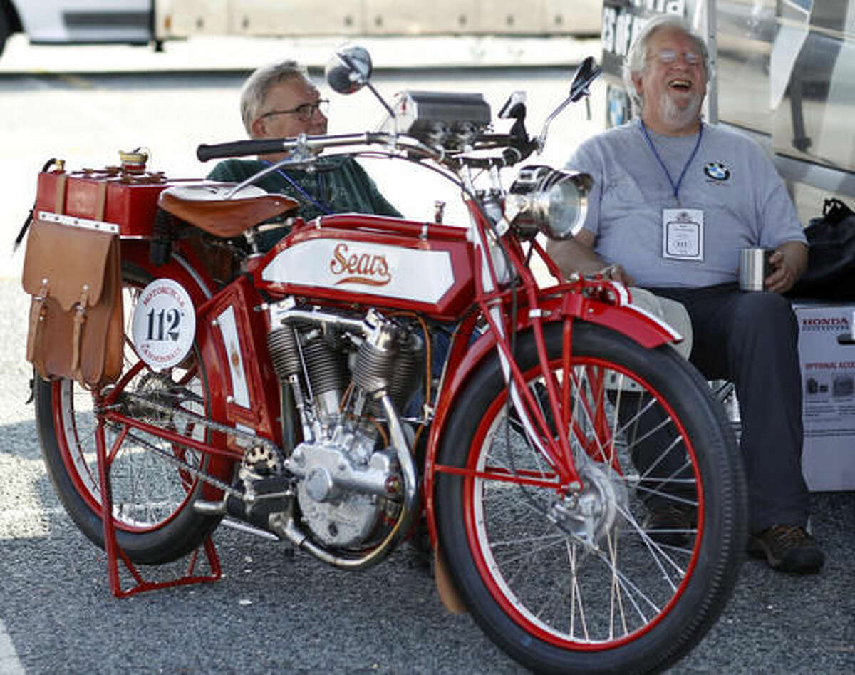 Bob Wooldridge, right, of Georgia, shares a laugh with Bill Kurtz, while sitting near their 1913 Sears Dreadnought motorcycle Thursday, Sept. 8, 2016, in Atlantic City, N.J., as they prepare for the Motorcycle Cannonball, a bi-annual run for vintage motorcyclists, that will take them almost 3,400 miles across the country from Atlantic City to San Diego, where they expect to arrive Sept. 25. This marks the fourth race since motorcycle expert Lonnie Isam Jr., founded the inaugural run in 2010, but the first that requires motorcycles at least 100 years in age. (AP Photo/Mel Evans)