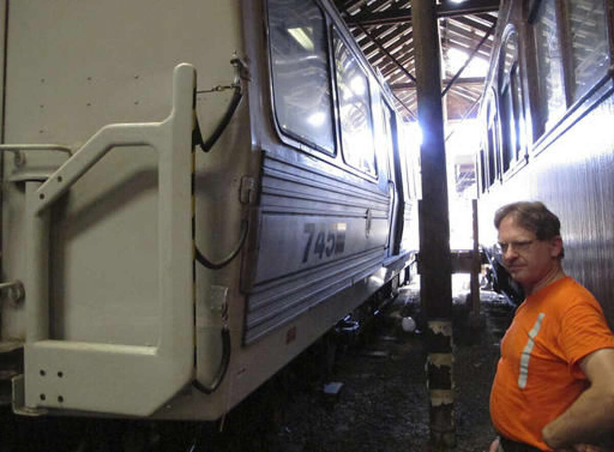 In this Aug. 17, 2016 photo, Conrad Misek, a conservator at the Shore Line Trolley Museum, stands outside PATH car 745 at the museum in East Haven, Conn. The subway car was beneath the World Trade Center in New York during the terrorist attack on Sept. 11, 2001. The museum will dedicate and open to the public an exhibit featuring the car on Sept. 11, 2016. (AP Photo/Dave Collins)
