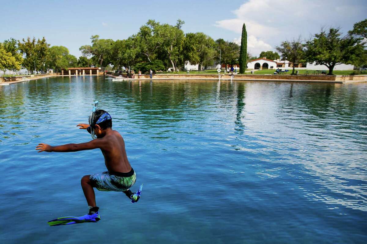 Dean Strong, 8, jumps into the crystal clear waters of the worlds largest spring-fed swimming pool in his snorkeling gear at Balmorhea State Park Friday, Sept. 16, 2016 four miles west of Balmorhea in Toyahvale, TX. Houston-based Apache Corporation recently announced the discovery of an estimated 15 billion barrels of oil and gas in the area and plans to drill and use hydraulic fracturing on the 350,000 acres surrounding the park. Apache has leased the mineral rights under the park and town, but has promised not to drill on or under either. Even with the promises, some residents worry that the drilling could affect the 15 million gallons of water that flow through the pool every day and impact the more than 200,000 visitors the pool attracts annually. ( Michael Ciaglo / Houston Chronicle )