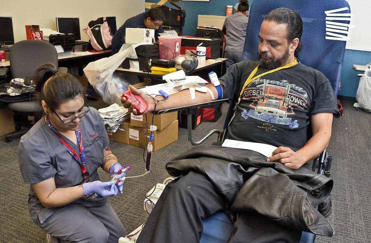 Norman Caciano, extends his arm as the South Texas Blood and Tissue Center's Monica Andalon draws blood into vials Monday, March 31 during a blood drive at Convergys. (Danny Zaragoza, File/Laredo Morning Times)