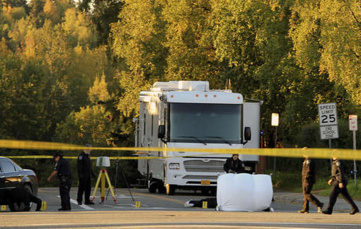 Anchorage police process a crime scene near two downtown schools in which a man was found fatally shot on Tuesday, Sept. 13, 2016, in Anchorage, Alaska. The intersection at 15th Avenue and C Street borders Central Middle School and is two blocks from Chugach Optional Elementary School. The shooting occurred before the schools opened but the schools were closed for the day. (AP Photo/Dan Joling)