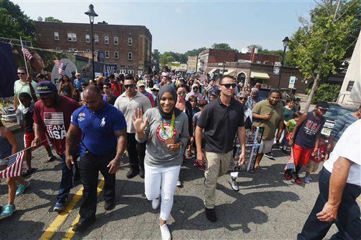 Ibtihaj Muhammad, center, who won a bronze medal in the women's team sabre event at Rio, marches in a parade held in her honor Saturday, Sept. 10, 2016, in Maplewood, N.J. She was the first U.S. athlete to compete while wearing a hijab. (Chris Pedota/The Record via AP)